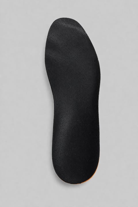 Black textured shoe sole with curved design on gray background